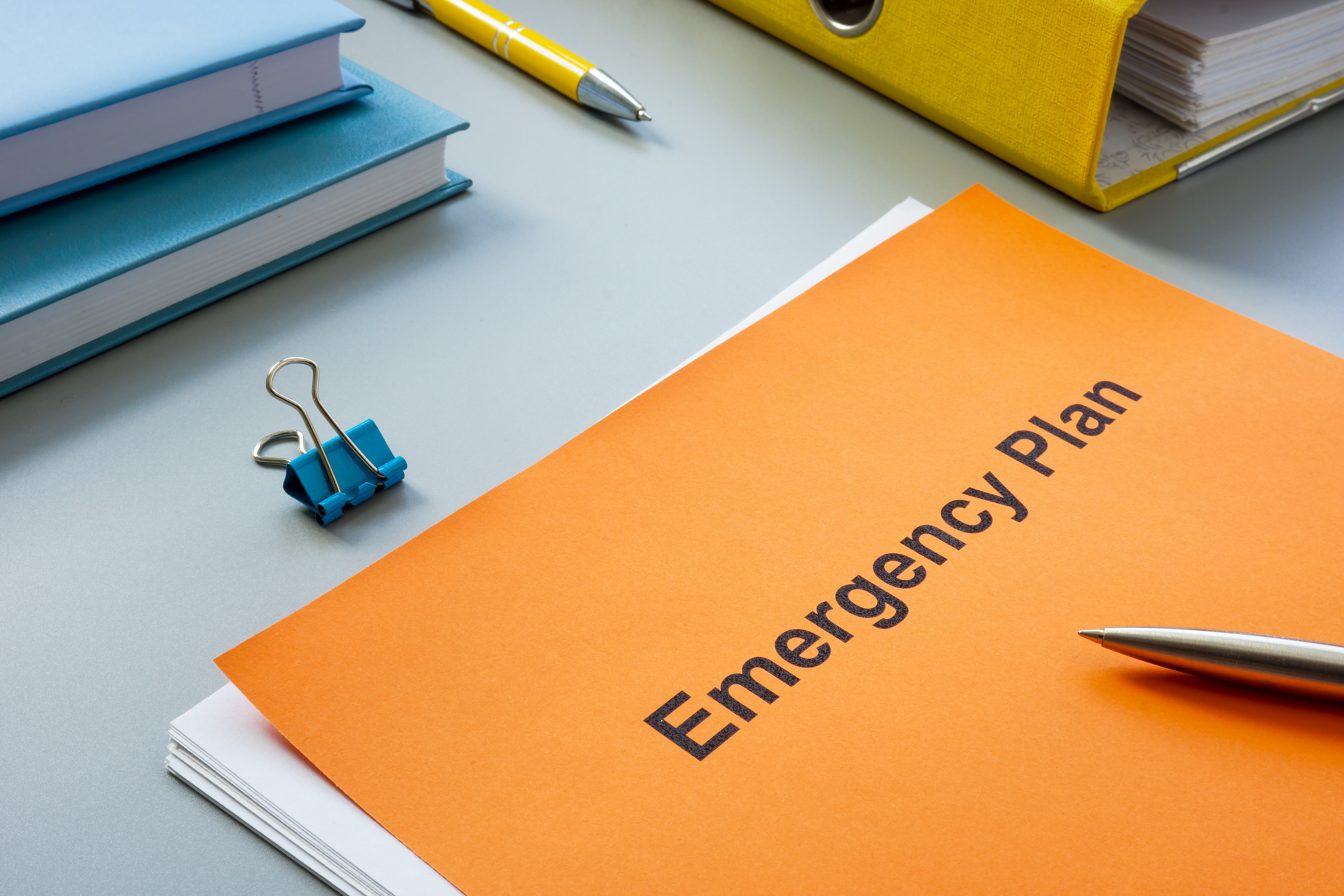 emergency plan near a yellow folder and pen.